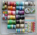 Une boîte transparente de ruban washi coloré et d'autres fournitures d'artisanat