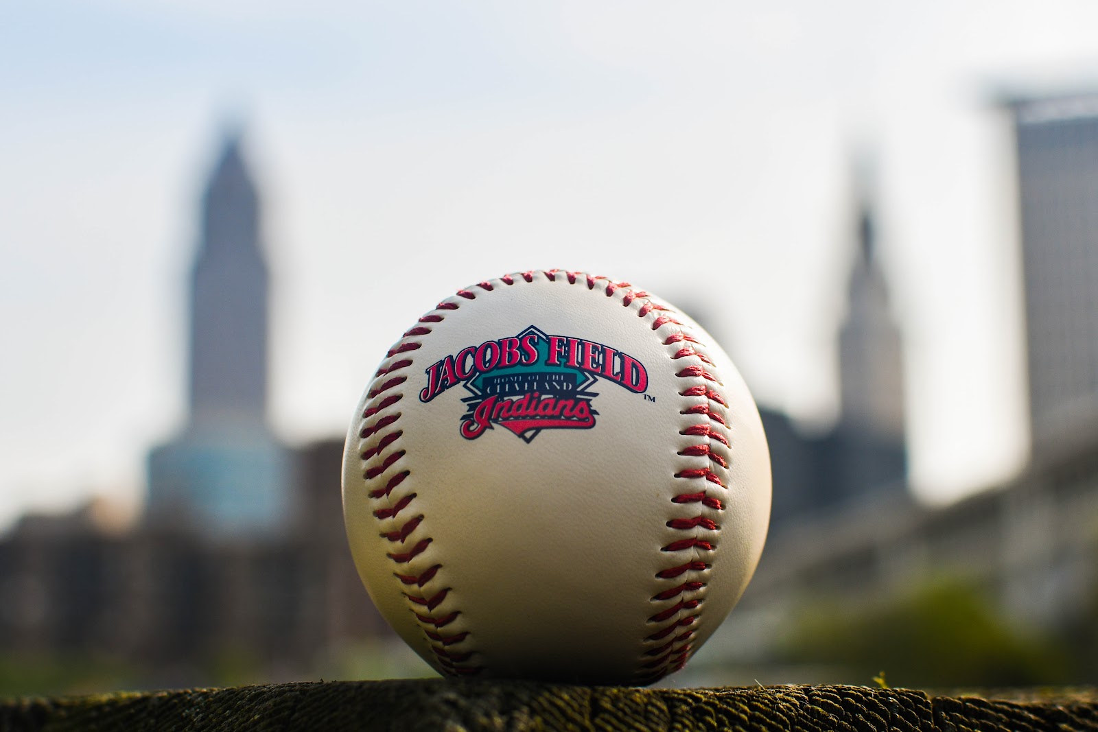 Un baseball est assis sur une surface avec "Champ Jacobs" Visible dessus, avec l'horizon de Cleveland floue en arrière-plan, représentant l'équipe de Cleveland Guardians que Trump veut renommer les Indiens.