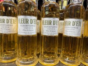 Plusieurs bouteilles en verre sur une étagère remplie de liqueur de fleur de sureau jaune pâle